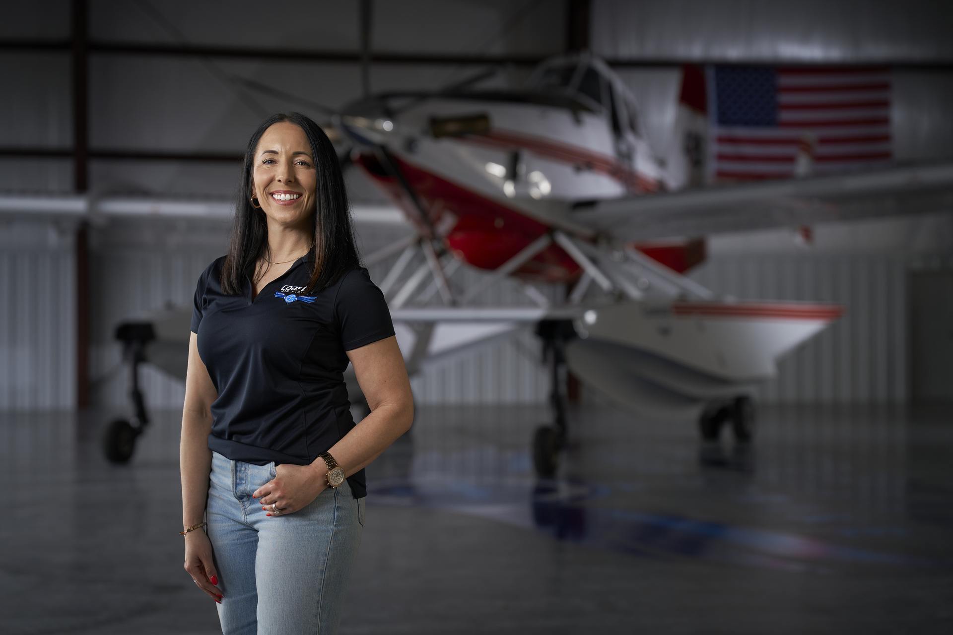 Woman standing in front of an airplane in a hangar.