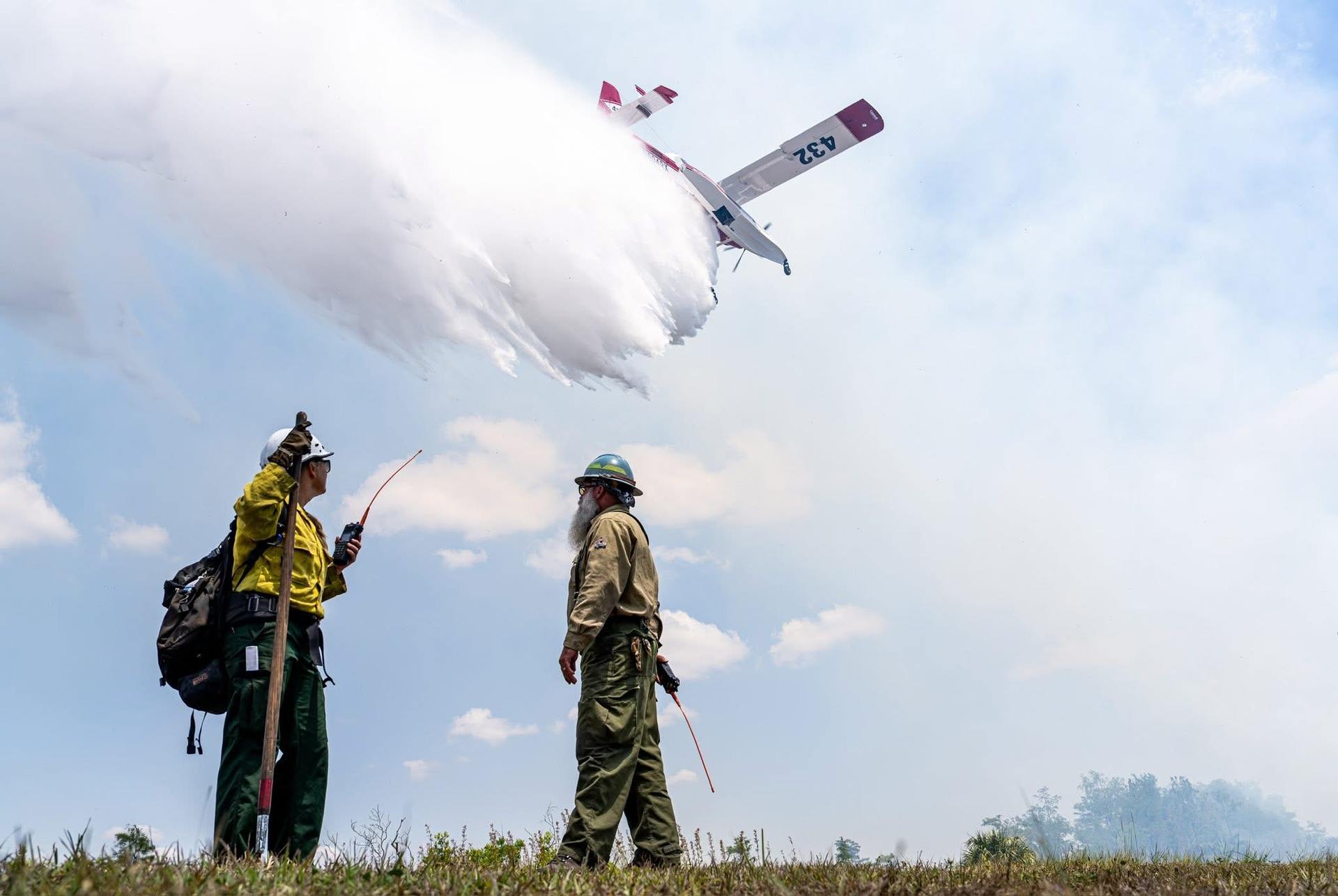 SES dropping water with firefighters in foreground