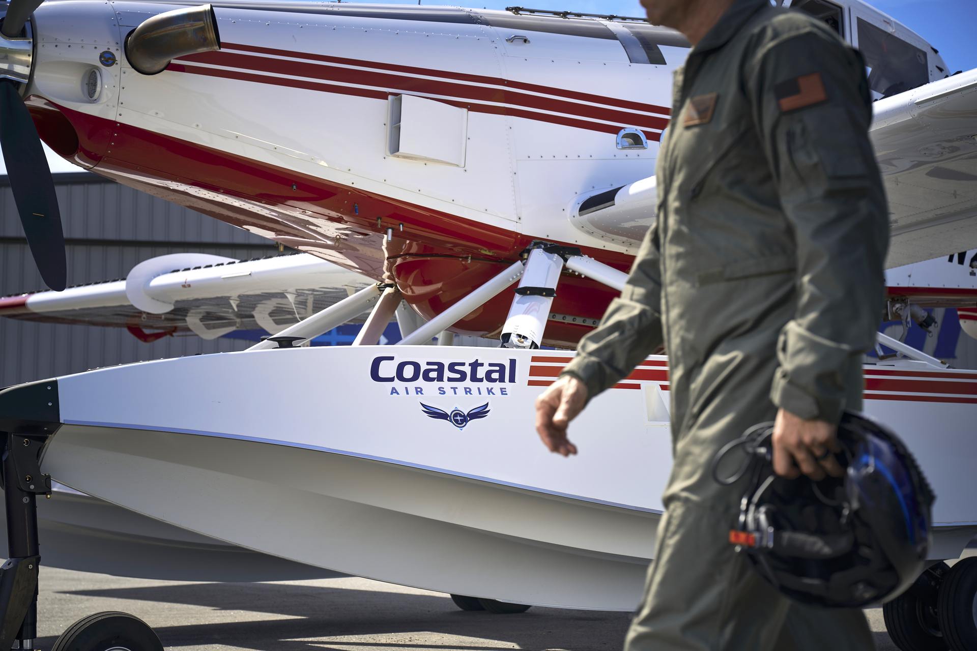 Pilot walking past aircraft.